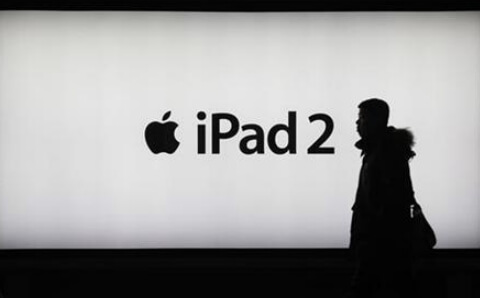 Мужчина идет мимо рекламы iPad 2 в Шанхае Мужчина идет мимо рекламы iPad 2 в Шанхае