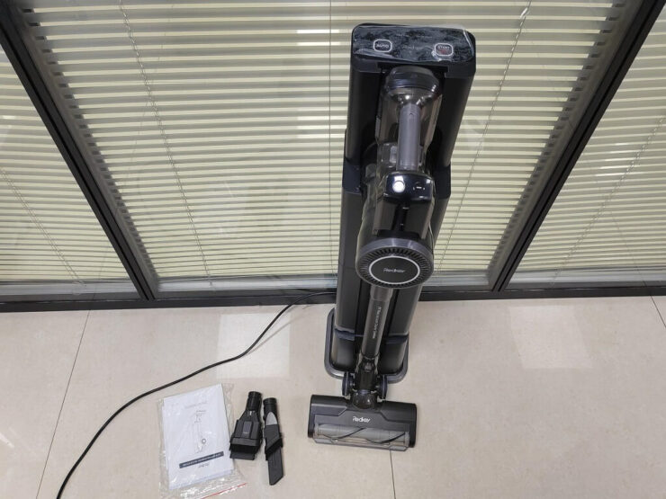 Пылесос со станцией самоочистки. Такая станция не только очищает пылесос, но и заряжает его. Фото.