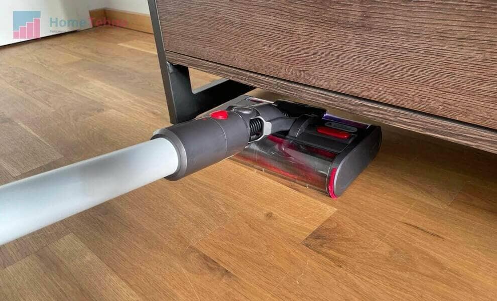 Высота щетки позволяет забраться даже под ящики и тумбочки. Фото.