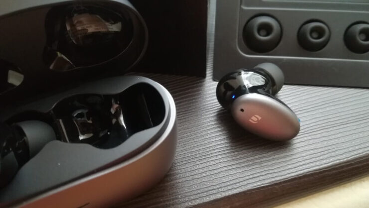 Беспроводные наушники Ugreen. На небольшую платформу-овал вынесли управление и микрофоны. Фото.