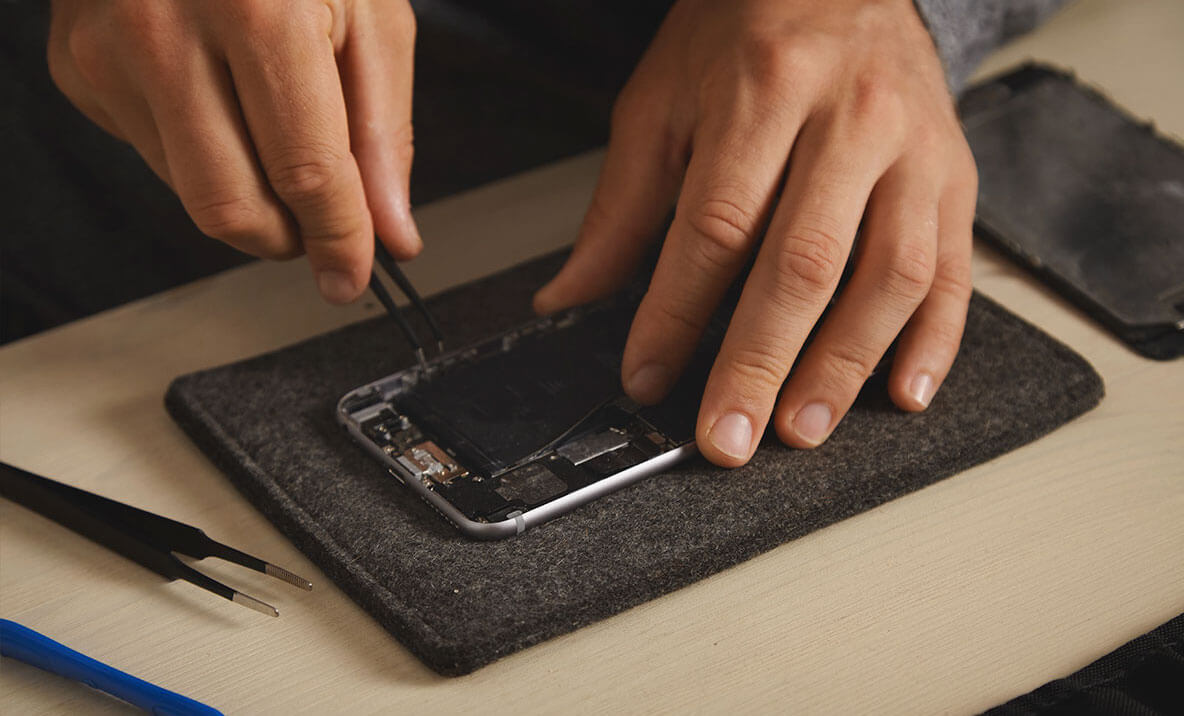 Замена аккумулятора на Айфоне. У Apple есть наборы для самостоятельного ремонта iPhone, и технически это соответствует требованию закона ЕС. Фото.