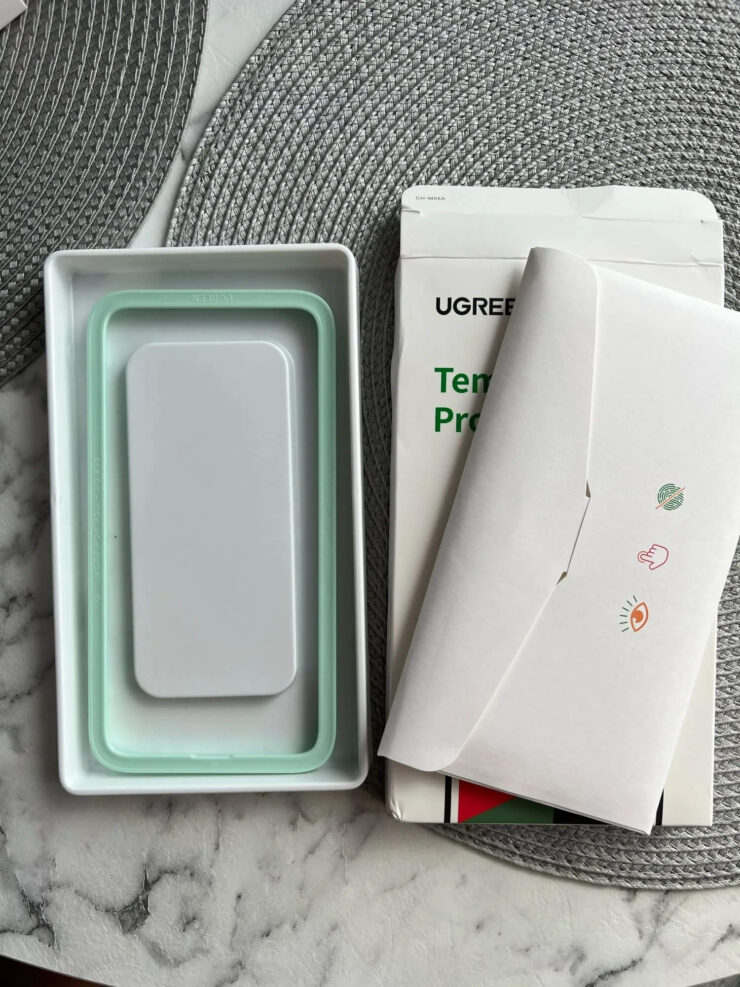 Защитное стекло для Айфона. Зеленая форма позволит наклеить стекло ровно. Защитное стекло для Айфона. Зеленая форма позволит наклеить стекло ровно. Фото.