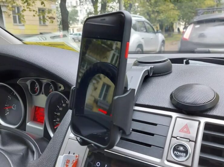 Держатель для телефона в машину. Такой держатель открывается с помощью кнопки с обратной стороны. Изображение: aliexpress.ru. Фото.