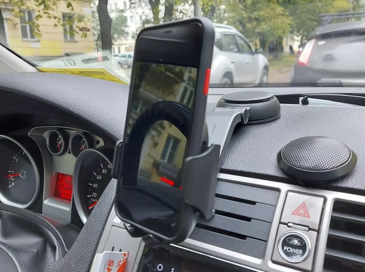 Держатель для телефона в машину. Такой держатель открывается с помощью кнопки с обратной стороны. Изображение: aliexpress.ru. Фото.