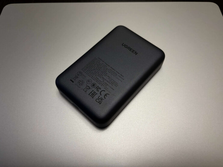 Магнитный внешний аккумулятор. На лицевой панели много надписей, связанных с характеристиками и сертификацией устройства. Фото.