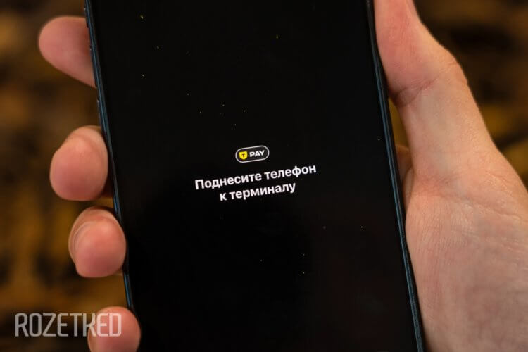 Оплата айфоном через Т-Банк. Просто поднесите смартфон к терминалу и дождитесь успешной оплаты. Изображение: rozetked.me. Оплата айфоном через Т-Банк. Просто поднесите смартфон к терминалу и дождитесь успешной оплаты. Изображение: rozetked.me. Фото.