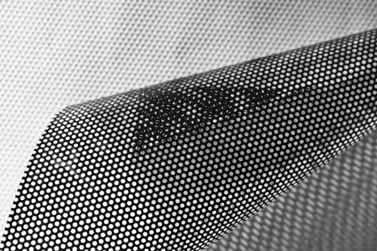 iPhone 18 Pro должен получить то, чего все ждут уже несколько лет. Это выбесит фанатов Android. Перфорированный экран отдаленно напоминает материал, на котором печатают «прозрачную» рекламу для маршруток. Изображение: Freepik. Фото.