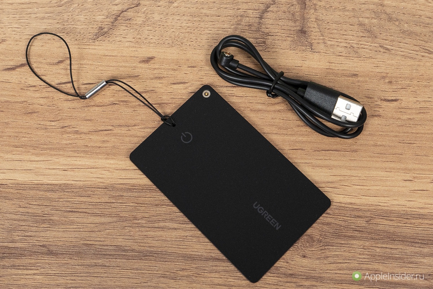 Как выглядит метка для поиска вещей. Кабель для зарядки и ремешок в комплекте. Но кабель лучше не терять, купить запасной будет сложно.. Фото.