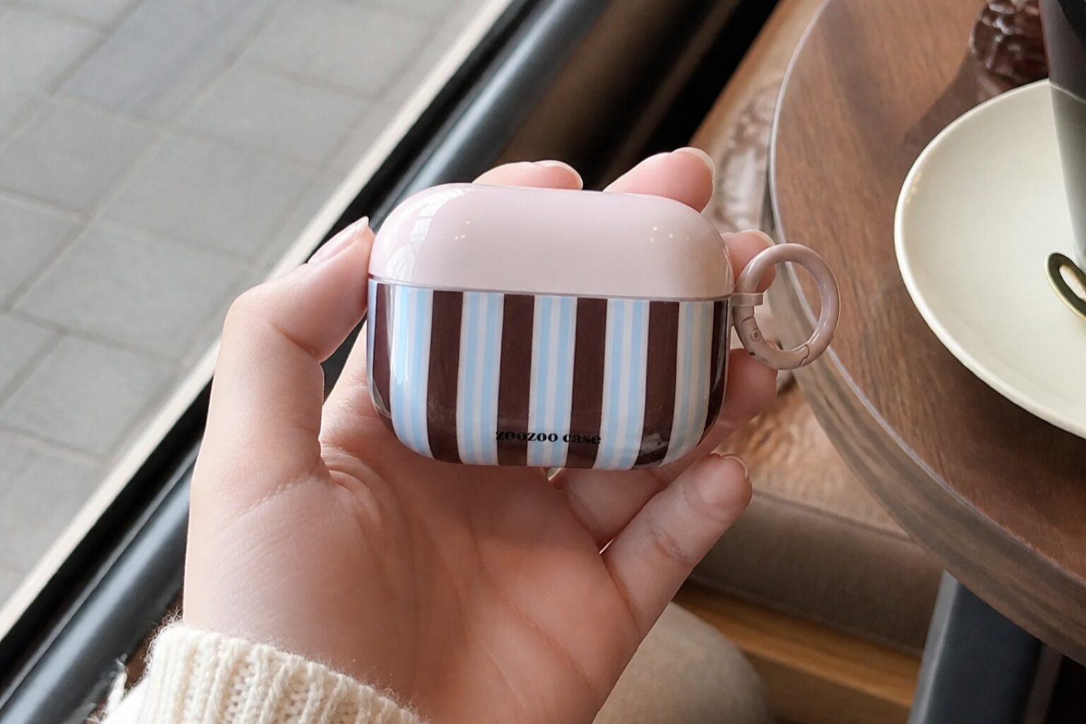Полосатый чехол-чашка для AirPods в руке