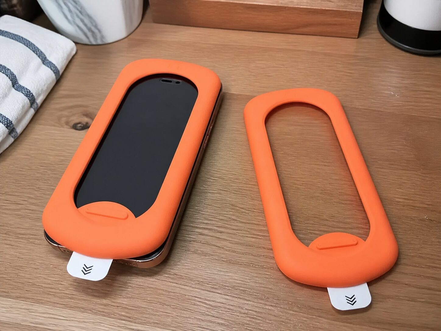 Оранжевая монтажная рамка для защитного стекла установлена на iPhone