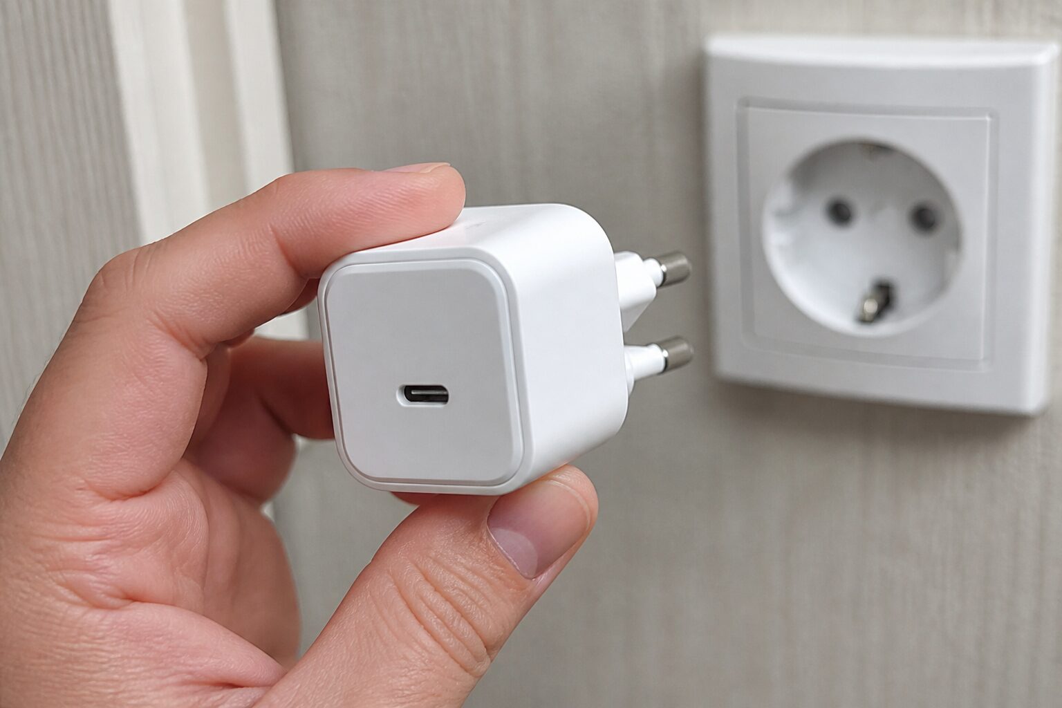 Компактный белый GaN-адаптер Ugreen на 45 Вт в руке