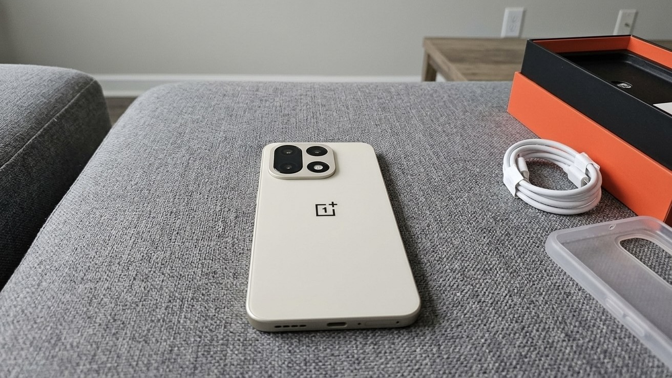 Смартфон OnePlus 15 рядом с коробкой, кабелем и чехлом
