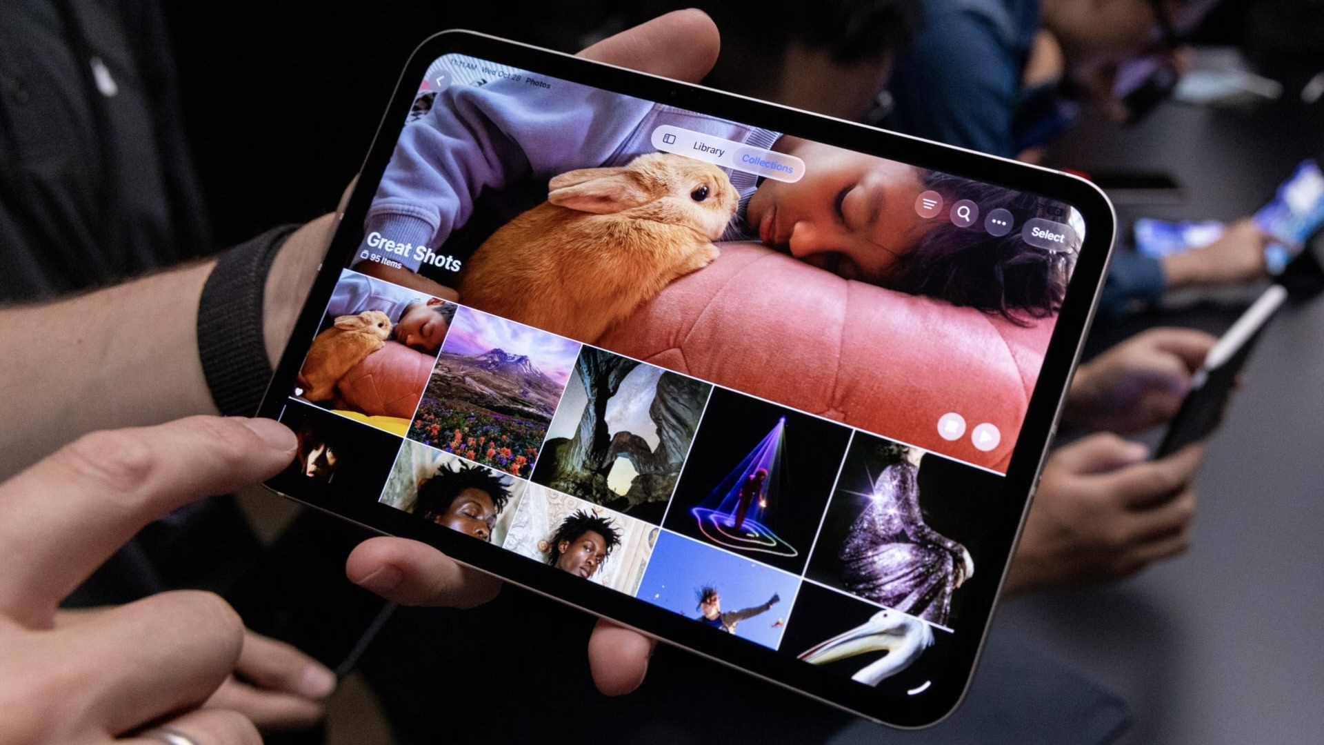 Новый iPad mini в руках, на экране подборка ярких снимков в приложении «Фото»