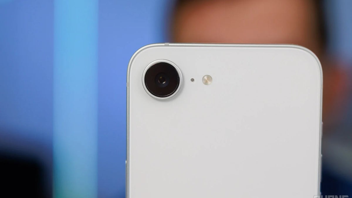 Крупный план одиночной камеры и вспышки на задней панели белого iPhone