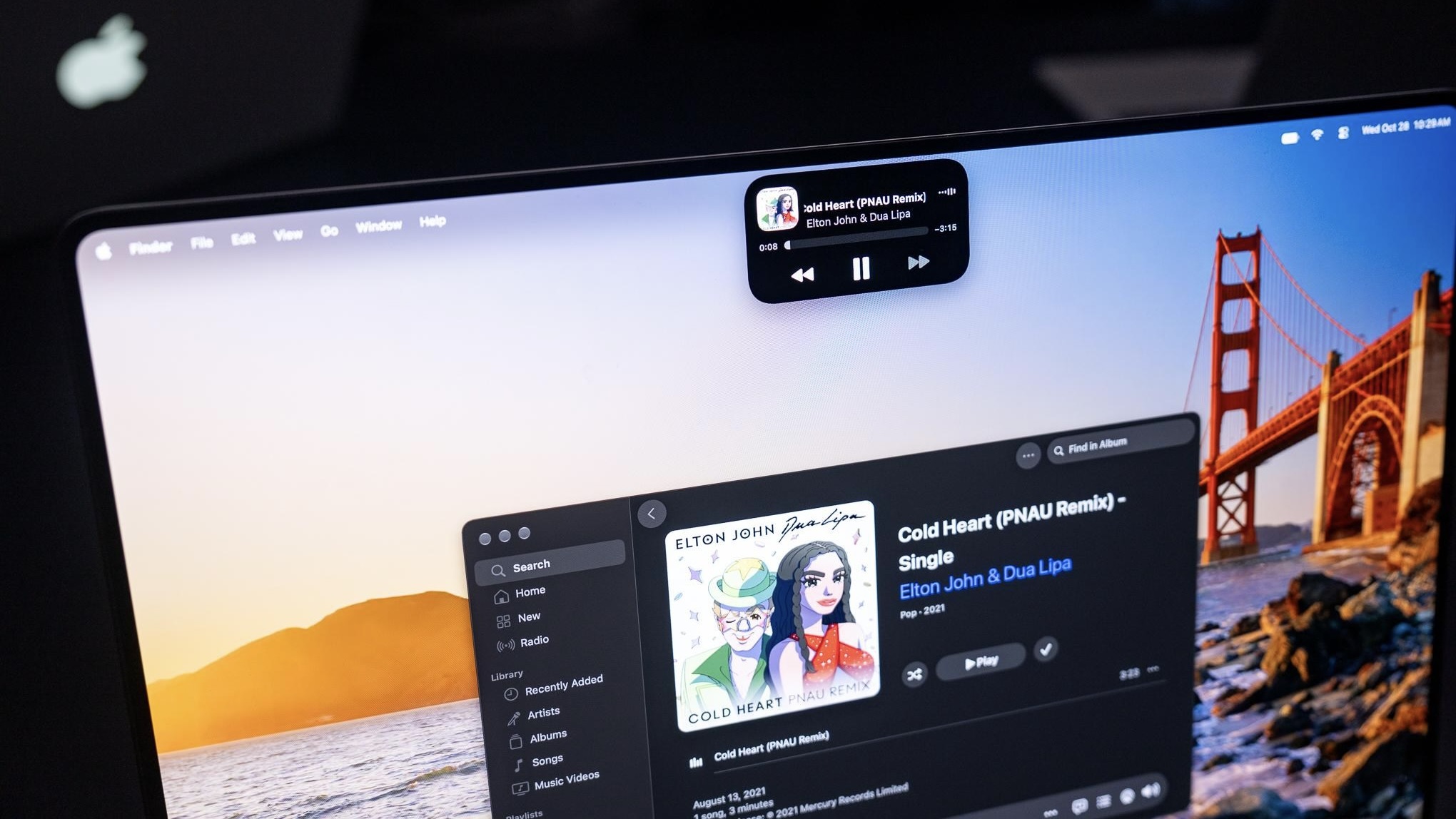Dynamic Island на экране MacBook Pro с плеером Apple Music и кнопкой паузы