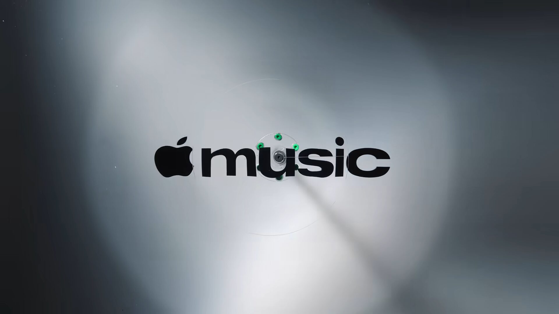 Черный логотип Apple Music на светлом фоне, по центру слова music закреплен преобразователь