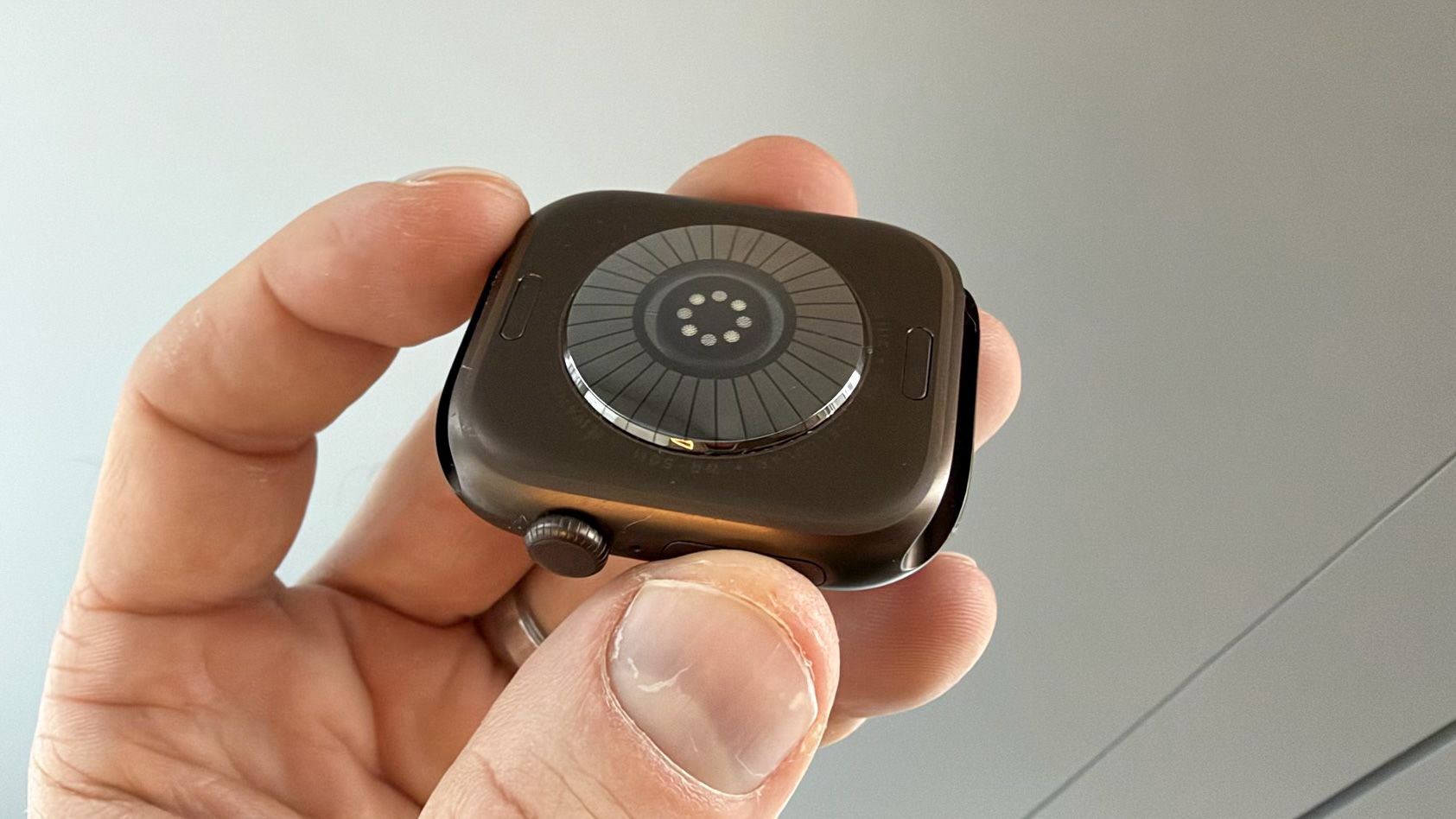 Задняя крышка Apple Watch Series 12 крупным планом, видны электроды и кольцо фотодиодов