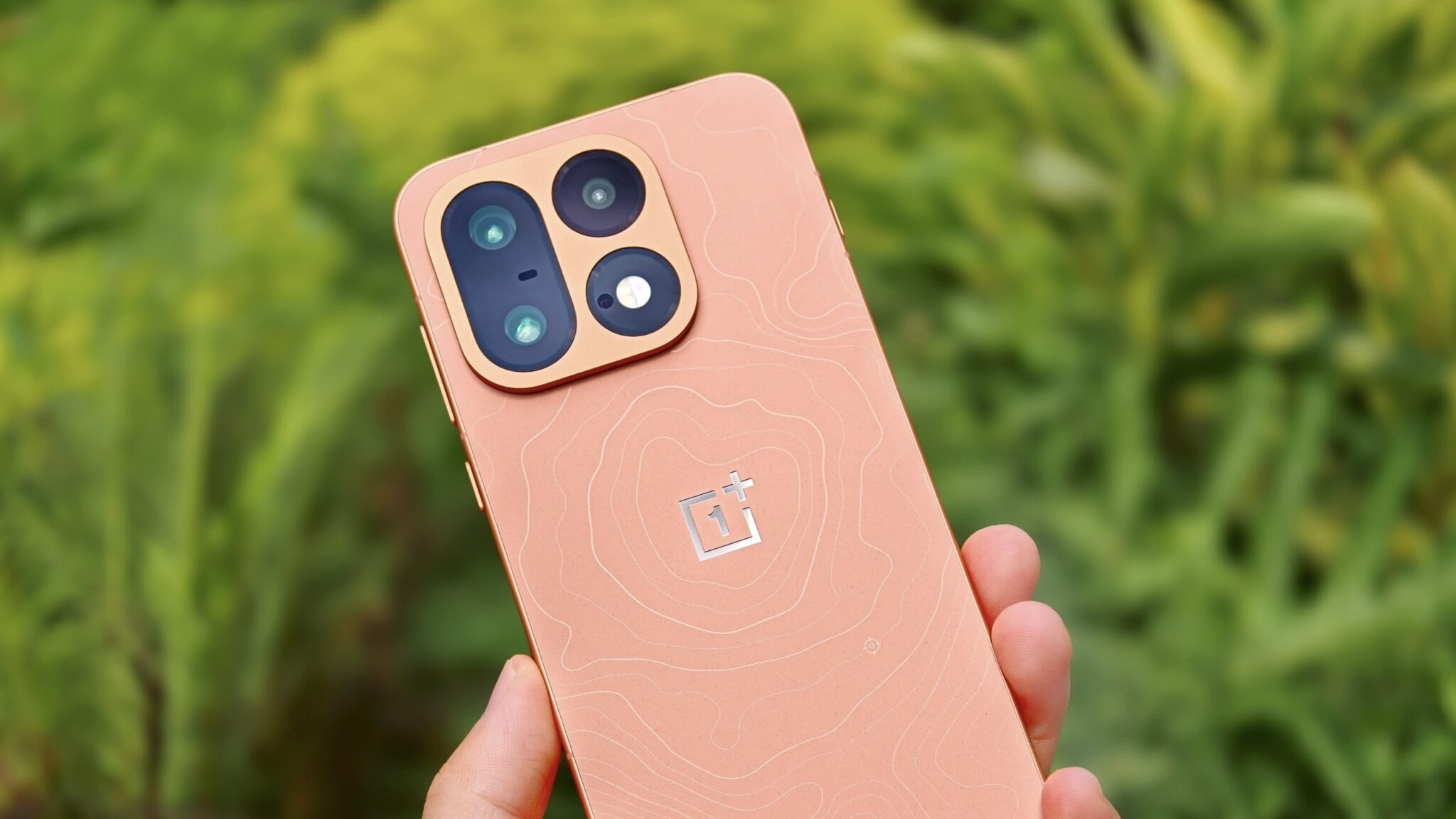 OnePlus 16 оранжевого цвета в руке