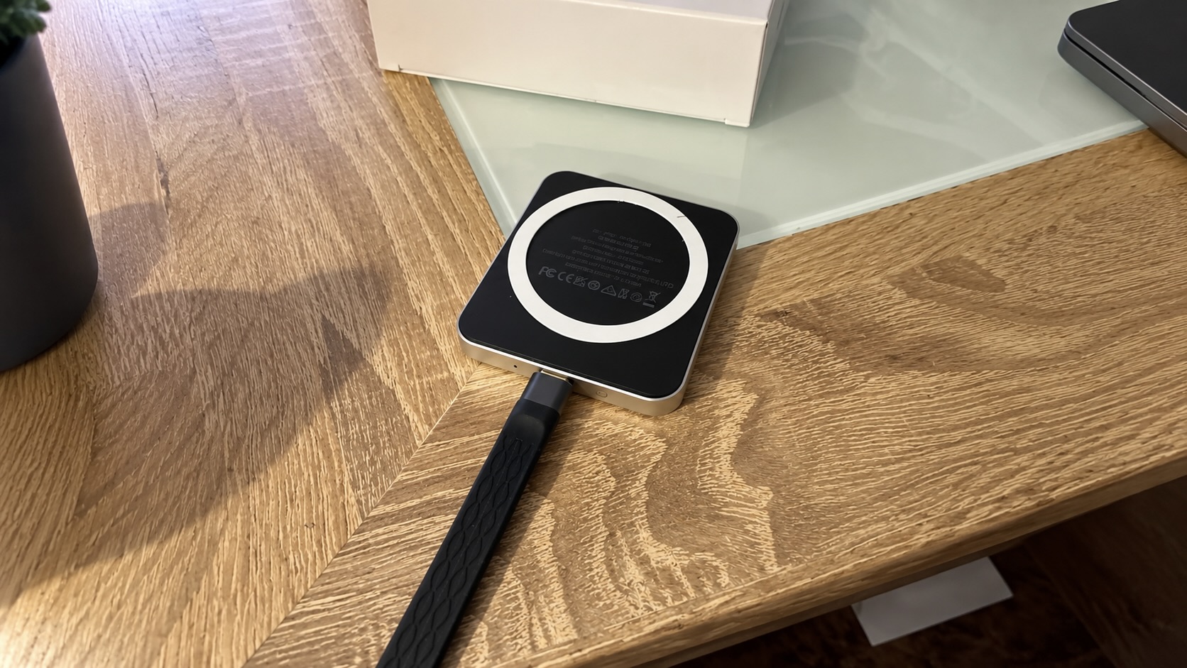 Обратная сторона SSD ORICO K15 Mini с белым магнитным кольцом MagSafe на деревянном столе